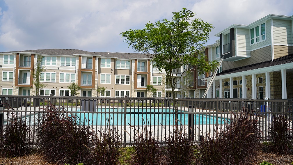 Green Oaks apartments exterior building with view of fenced pool