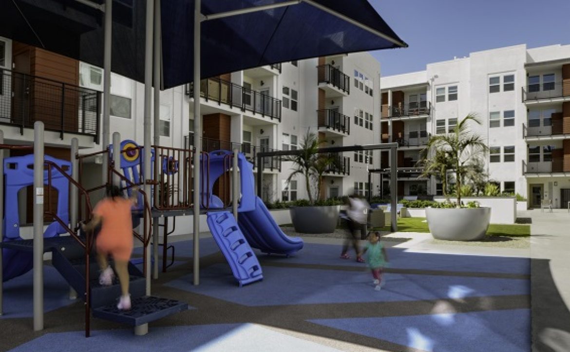 Las Ventanas apartments playground area with children and adult