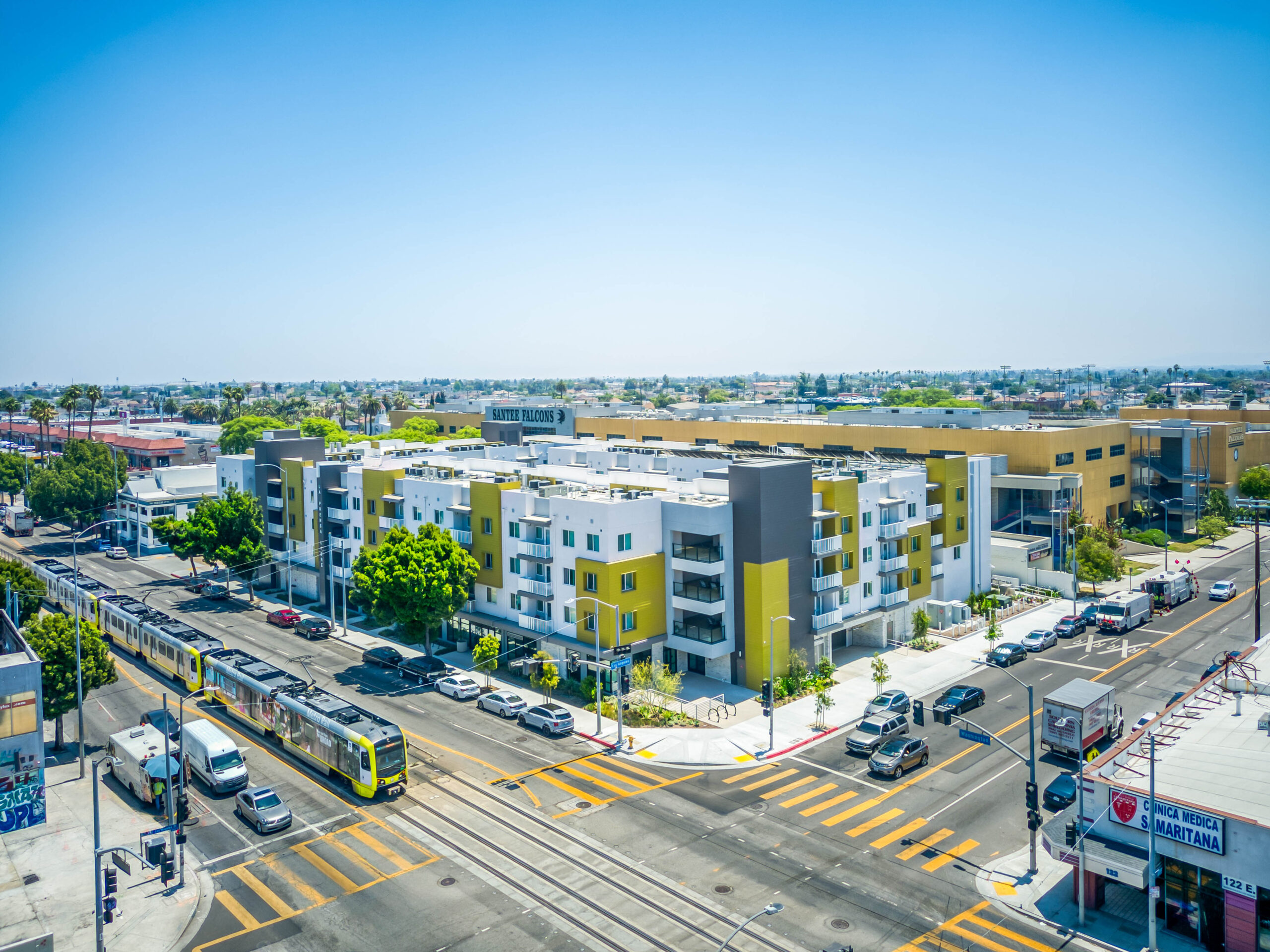 La Prensa Libre corner aerial view with train running in front of development
